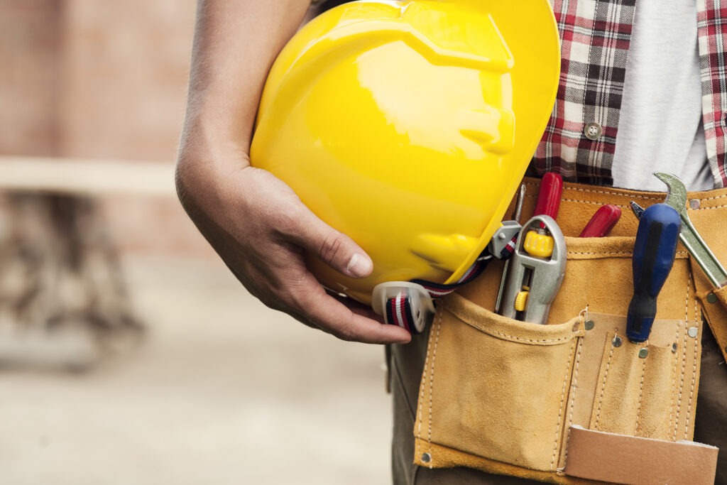 close up hard hat holding by construction worker