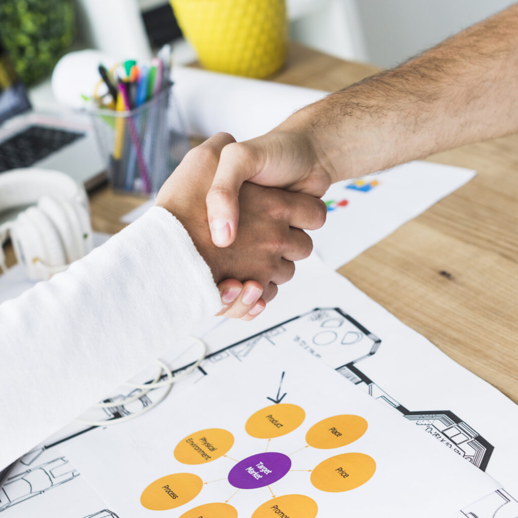 close up two businessmen shaking hands desk